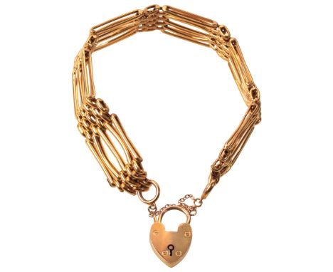 A VINTAGE GATE-LINK BRACELETin 9ct gold, comprising a series of stylised gate links, secured with a heart-shaped padlock clas