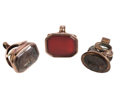 THREE ANTIQUE FOB SEALSin chased gold, two set with carved smoky quartz intaglio seals, the other set with a blank carnelian 