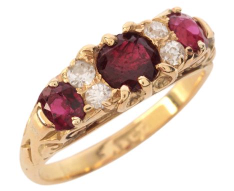 A RUBY AND DIAMOND RINGin 18ct gold, set with three graduating cushion cut rubies, totalling c.1.53 carats, alternating with 