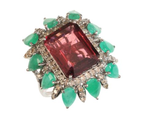 A MULITI-GEM COCKTAIL RINGset with a step cut red tourmaline of c.8.47 carats, surrounded by a cluster of pear cut emeralds, 