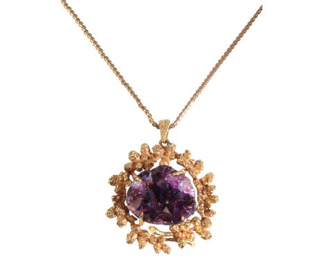 A VINTAGE AMETHYST GEODE PENDANT NECKLACEin 9ct gold, set with an amethyst geode held in a stylised modernist mount, suspende