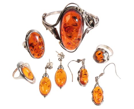 A COLLECTION OF AMBER JEWELLERYin sterling silver, including a bangle in a stylised floral design, set with a large amber cab