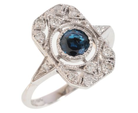 A SAPPHIRE AND DIAMOND PLAQUE RINGin 9ct white gold, set with a round cut sapphire of c.0.65 carats, to an openwork plaque se