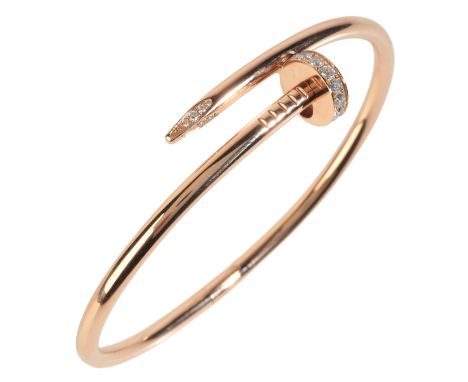 CARTIER: A DIAMOND 'JUSTE UN CLOU' BRACELET in 18ct gold, designed as a crossover nail bangle, accented by round brilliant cu