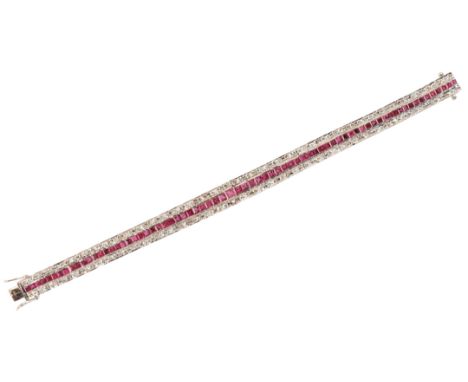 A RUBY AND DIAMOND BRACELETin 18ct white gold, set with a row of calibré cut rubies, totalling c.3.30 carats, flanked by two 