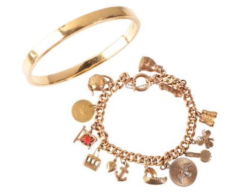 A VINTAGE CHARM BRACELETin 9ct gold, comprising a series of curb links, suspending thirteen charms, secured with a bull ring 