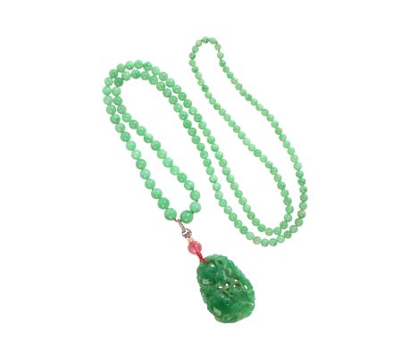 A JADE NECKLACEcomprising a series of graduating jadeite jade beads, suspending a carved jadeite jade pendant, surmounted by 