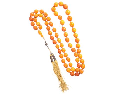 AN AMBER NECKLACEcomprising a single row of sixty-six amber beads, graduating from c.13.0-17.0mm, c.110.0cm / 43.3in, (c.56.2