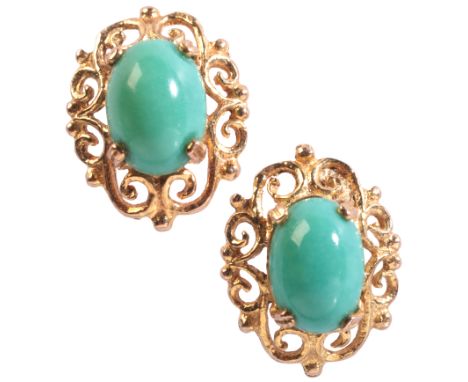 A PAIR OF TURQUOISE STUD EARRINGSin 9ct gold, each set with a turquoise cabochon held in a claw setting over a stylised borde