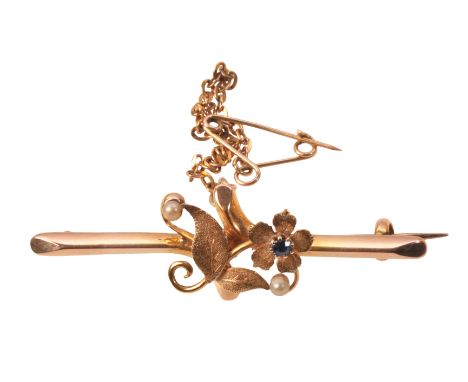 AN ANTIQUE SAPPHIRE AND PEARL FLOWER BROOCHin 15ct gold, comprising a flower motif with textured finish, set with a round cut