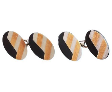 A PAIR OF VINTAGE CHEVRON CUFFLINKSeach comprising two oval terminals of carved onyx, overlayed with 18ct white gold with a g