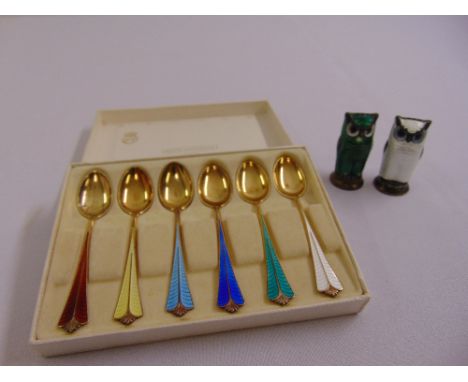 A cased set of Norwegian white metal and enamel teaspoons and a pair of white metal and enamel condiments in the form of owls