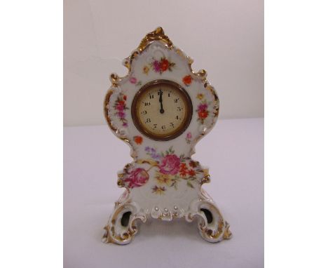 A continental ceramic watch case decorated with floral sprays, the watch with Arabic numerals