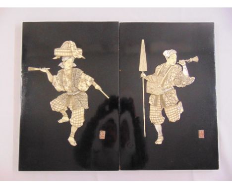 A pair of Chinese19th century carved ivory figurines in relief on black lacquered panels