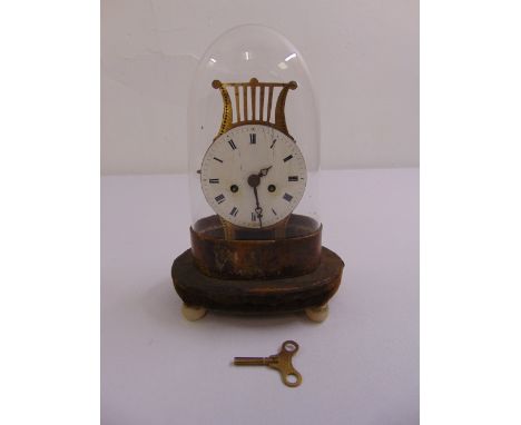 A 19th century continental mantle clock, white enamel dial on circular stand with three bun feet and detachable glass dome