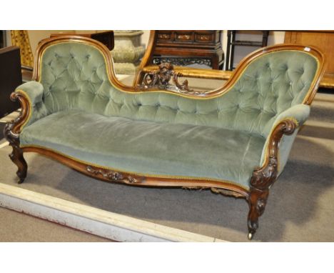 A Victorian upholstered chair-back sofa,
with elaborate carved and shaped mahogany show-wood surround on cabriole legs, lengt