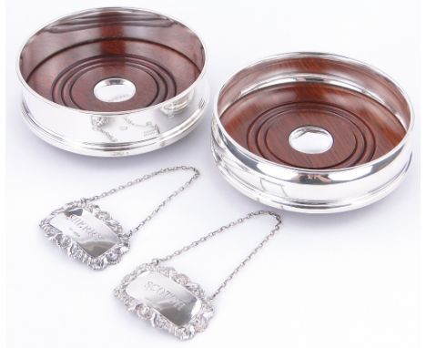 A pair of Carrs modern silver and turned wood wine coasters,
12.5cm across and a pair of silver decanter labels.