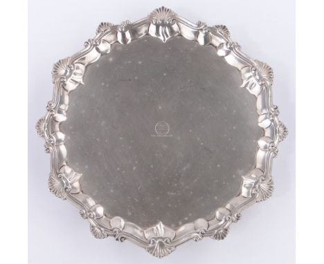 An 18th century circular silver tray,
with shell cast and shaped surround and hoof feet, makers marks E C, London 1766, 17 oz