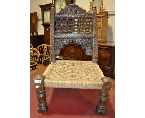 A carved hardwood Indian stool with woven seat. (des changed)