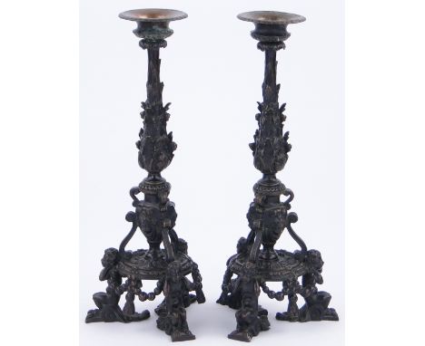 A pair of ornate bronze candlesticks 
supported by Pan figures, height 13".