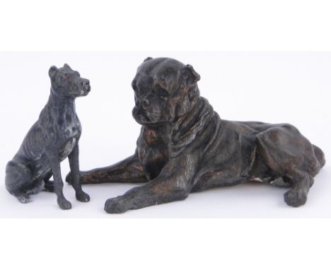 A bronze patinated spelter reclining dog,
circa 1900, length 6.25" and a smaller spelter dog height 3.25", (2).