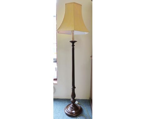A turned wood standard lamp with shade