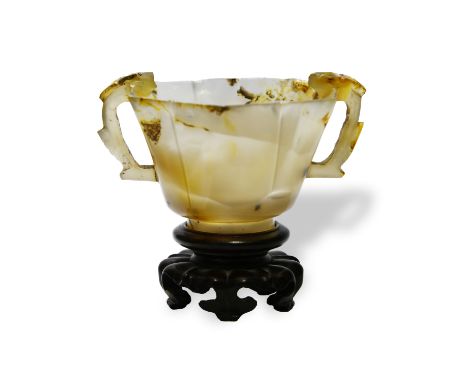 A RARE AGATE FOLIATE-SHAPED CUP AND WOOD STAND明或更早 瑪瑙雙龍耳茶盞Ming Dynasty or earlierThe stone, adorned with natural beige ripple