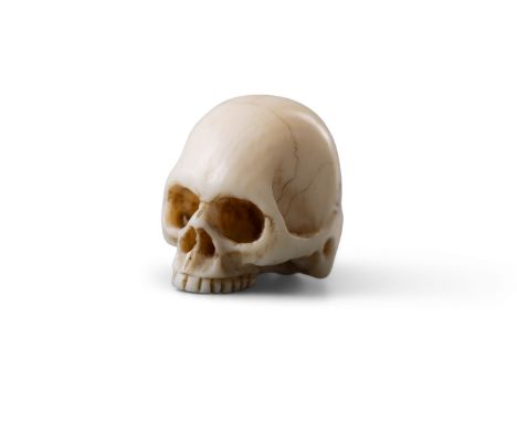 λ A IVORY MODEL OF A CARVED SKULL  Japan, Meiji Period (1868-1912)inked with signature.Size. 2.2 x 2cmProvenance: An Irish la