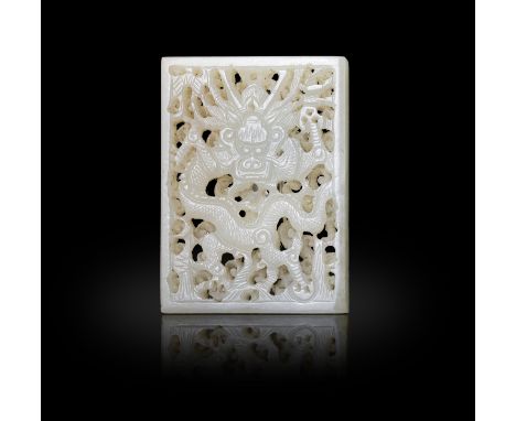 A CELADON JADE RETICULATED 'DRAGON' PLAQUE明代 白玉鏤空正面龍紋帶飾 China, Ming dynasty. The regular celadon jade plaque finely carved an