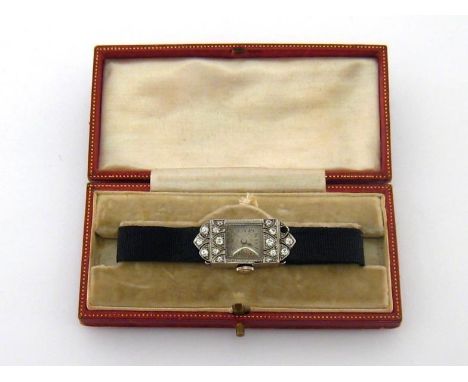 An Art Deco platinum and diamond cocktail watch, the rectangular hinged case set with small cushion cut stones (one missing),