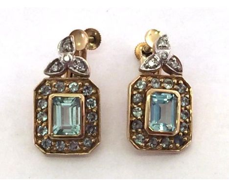 A 9 carat gold, aquamarine, green quartz and diamond ear clips, the central emerald cut aquamarines 6.7 x 5mm, in a surround 