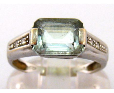 An aquamarine and diamond ring, the central rectangular cut stone, 9.2 x 7.2 x 4mm, to small brilliant cut shoulders, the sha