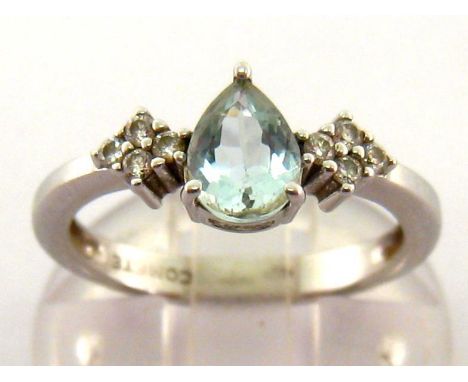 A diamond and aquamarine ring, the central pear cut aquamarine approx. 0.54 carat, with a quatrefoil of small brilliants to e