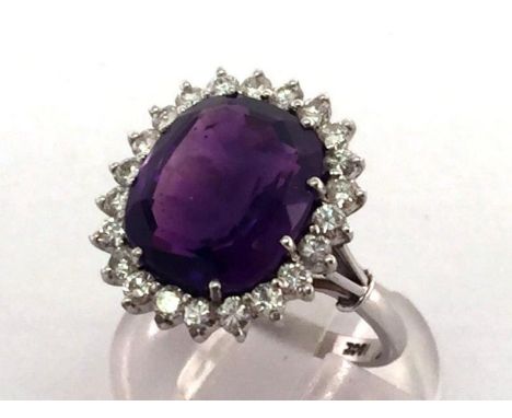 An amethyst and diamond cluster ring, the large rectangular mixed cut stone 13 x 11.2mm, in a surround of brilliants totallin