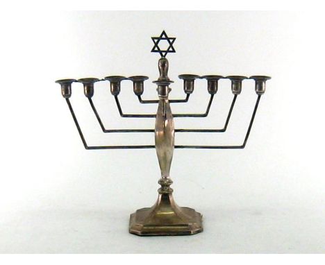 A silver menorah on octagonal foot, Birmingham, 1939, complete with auxiliary light to front, filled base, 23 cm. high  Good 