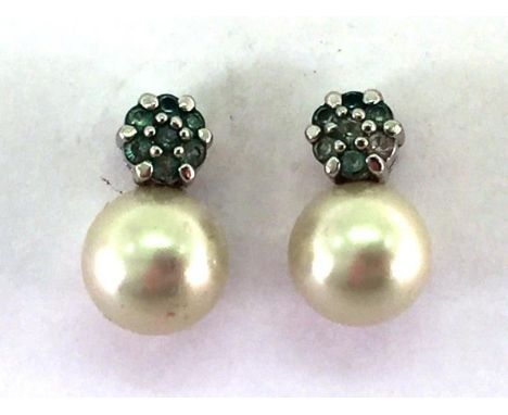 A pair of cultured pearl ear studs, the two round pearls 11mm diameter, to a green stone cluster top, mounted in white metal,