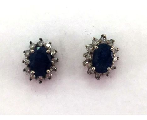 A pair of sapphire and diamond cluster ear studs, the oval cut sapphires 7 x 5mm, in a surround of small brilliants, butterfl