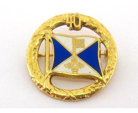 YACHTING INTEREST: An enamel brooch, with central blue and white pennant with painted gold key motif, within a wreath, stampe
