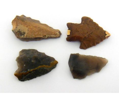 A gold mounted (tests 15 carat) flint arrow head, 4.5cm long, together with three further unmounted arrow heads (4) 
