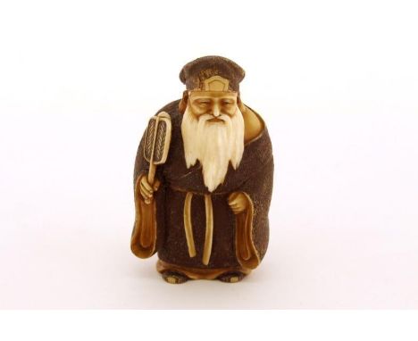 A very finely carved and stained Japanese ivory netsuke of a long bearded Japanese sage with a fan, depicts wearing a tan-col