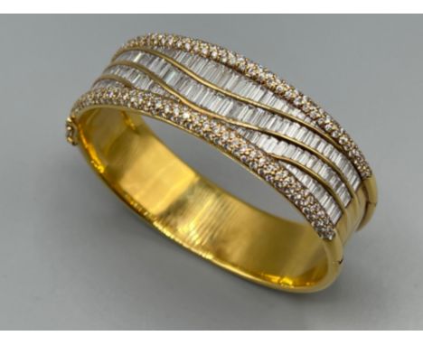18ct gold ladies 24ct diamond cluster bangle. Comprising of 224 round brilliant cut diamonds set in claw settings. 137 baguet