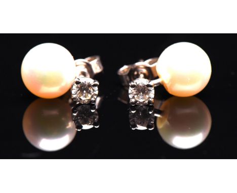 A pair diamond studs, set with round brilliant cut diamonds, estimated total diamond weight 0.31 carats, including white pear