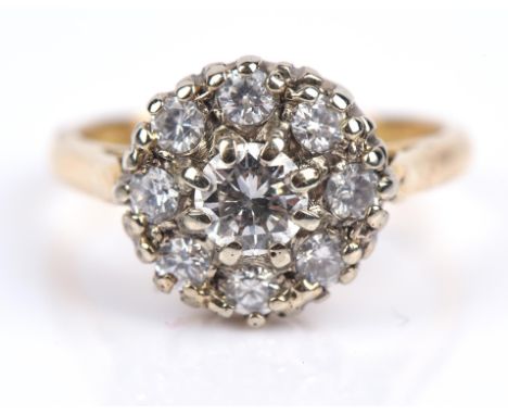 A diamond cluster ring, central round brilliant cut diamond, surrounded by eight round brilliant cut diamonds, weighing an es