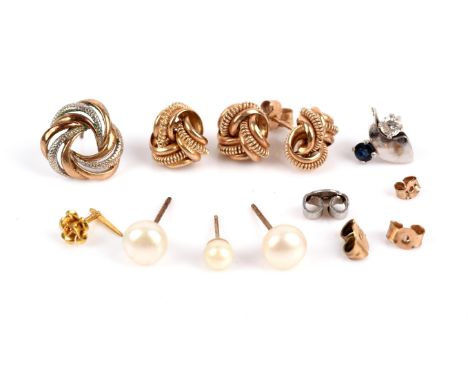 A group of earrings, including a pair of knot earrings, a pair of pearl earrings, a single pearl earring, a single rose earri