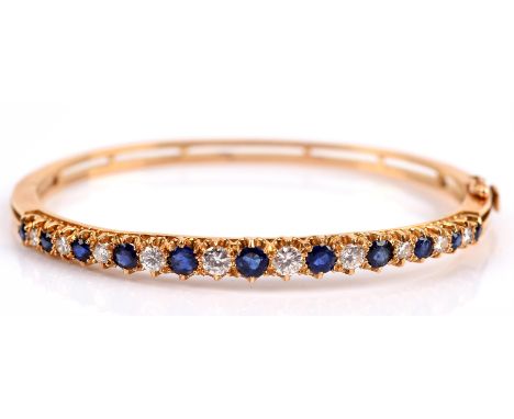 Sapphire and diamond hinged bangle, set with alternating round brilliant cut diamonds and round cut sapphires, graduating in 