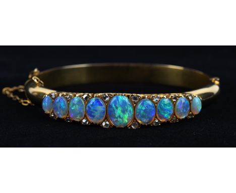 Opal and diamond hinged bangle, set with nine graduating oval cabochon cut opals intermittently set with rose cut diamonds, w