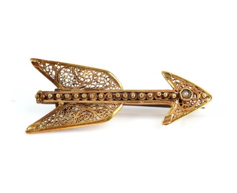 Filigree brooch in an arrow motif, with scrollwork filigree, and a seed pearl set to the head of the arrow, in gold testing a