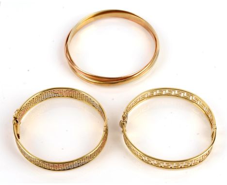Three 9 ct gold bangles, one a tricolour Russian bangle, one a tricolour hinged bangle with safety clips, and one a hinged Gr