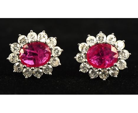 Ruby and diamond floral cluster earrings, central oval cut ruby weighing an estimated 2.25 carats, surrounded by twelve round