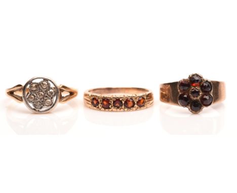 Three rings, including a garnet five stone ring, in tested 9 ct, size E, a garnet floral cluster ring, in tested 9 ct, size F